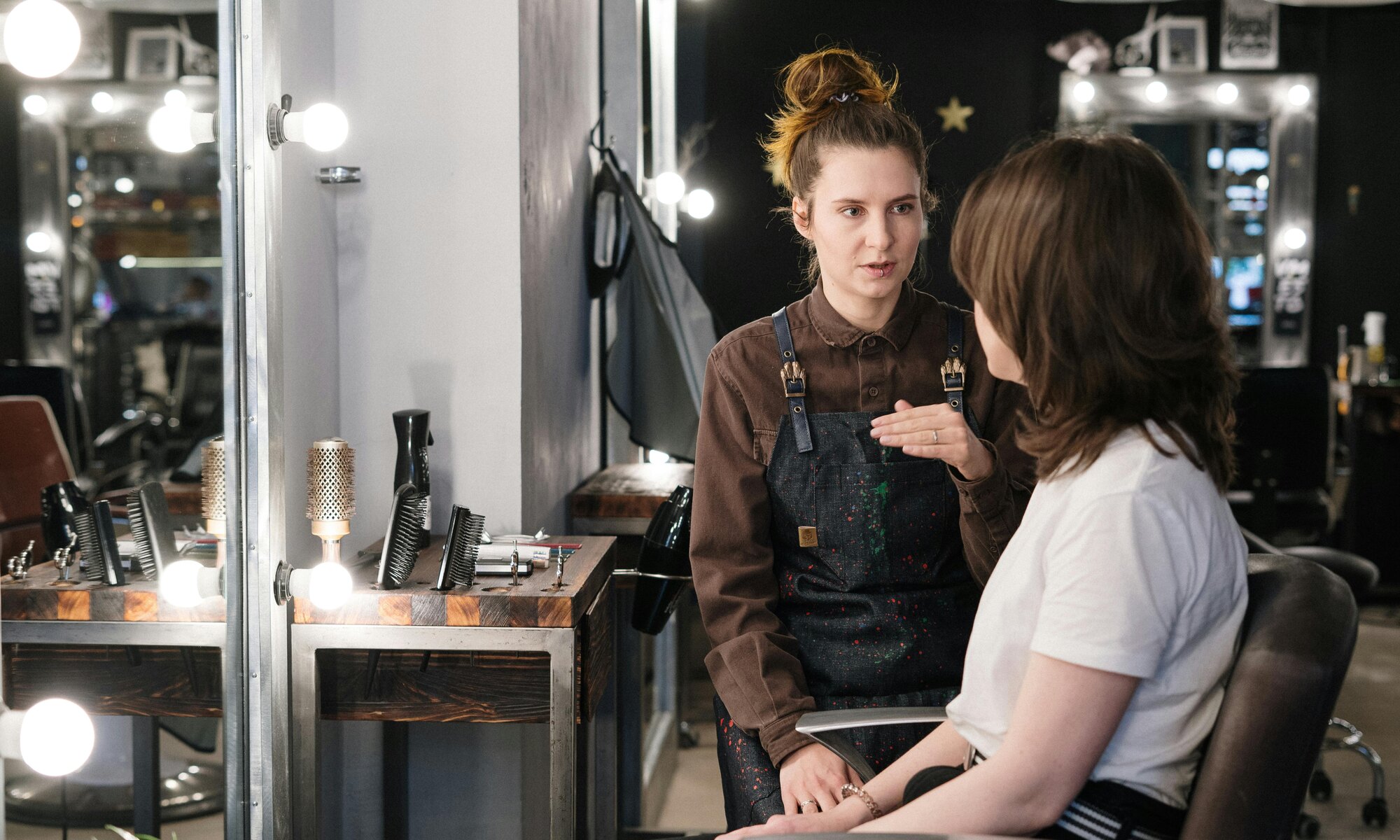 Stylist consulting with a client in front of salon mirrors